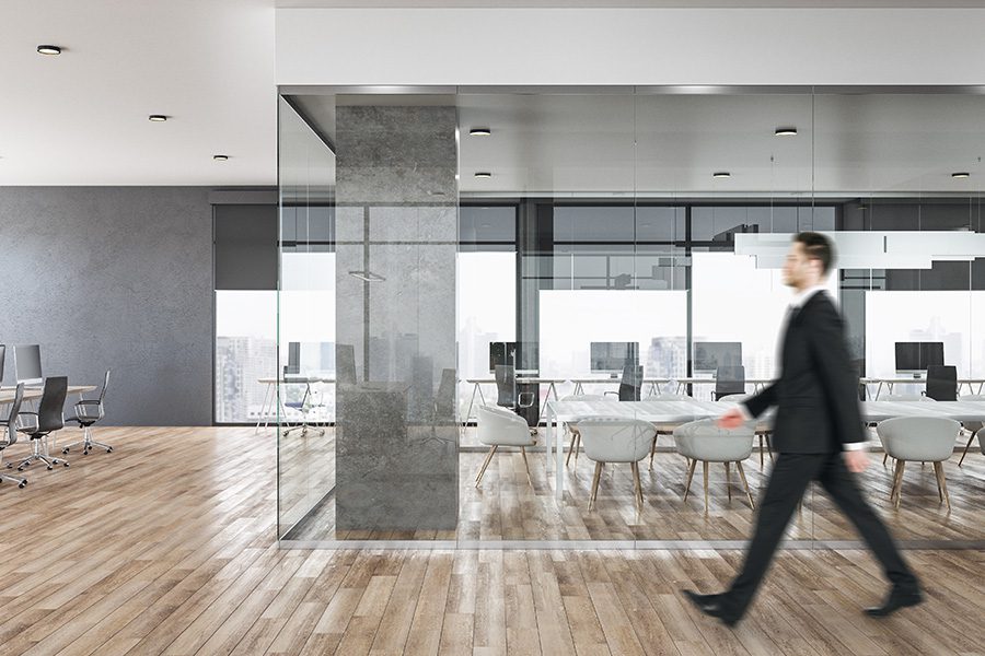 Business Insurance - Businessman Blurred While Walking in a Contemporary Concrete Business Office Interior