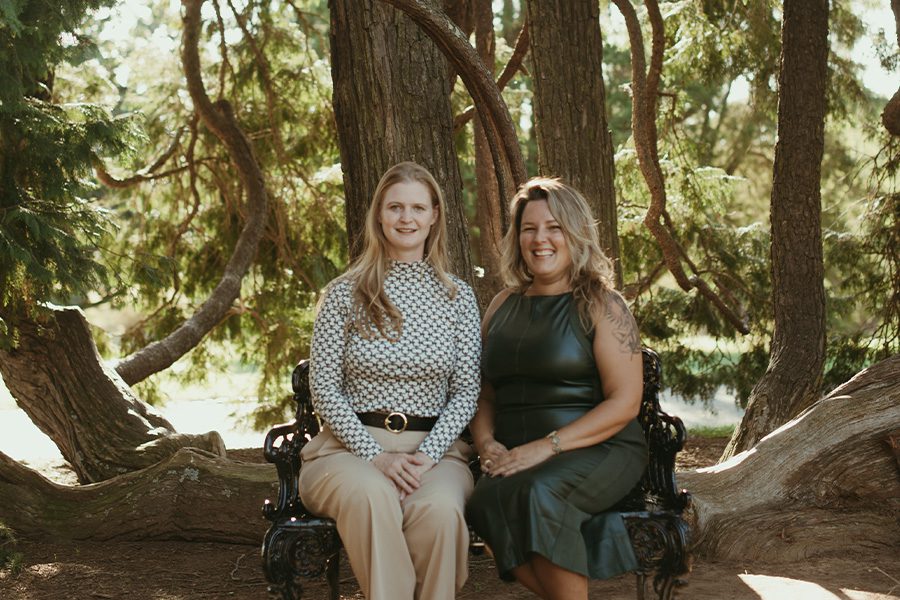 About Our Agency - Portrait Photo of Emily and Mary Sitting on a Park Bench